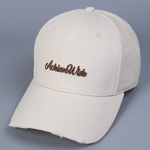 Detailed close-up of beige cotton baseball cap featuring Achieve Wish embroidery and frayed brim