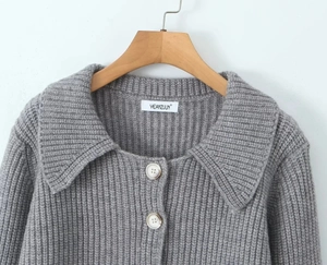Détail du cardigan en maille côtelée grise avec col à revers et boutons blancs texturés