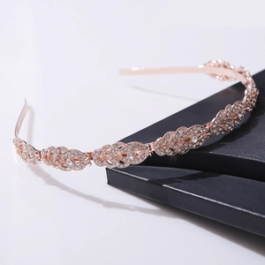 Close-up of rose gold leaf tiara with sparkling rhinestones on black display stand