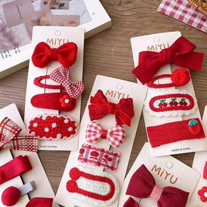 Red bow and floral knit hair clips set for girls on a warm rustic display card