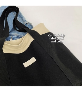Close-up of black and white canvas tote bag showing durable fabric and brand patch