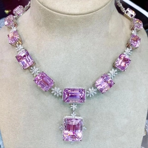 Luxurious pink emerald-cut gemstone necklace with floral diamond accents on mannequin