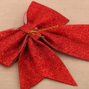 Close-up of sparkling red glitter bow with gold wire detail for Christmas decoration