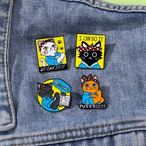 Cartoon cat metal enamel badges in Rosie the Riveter pose on denim background