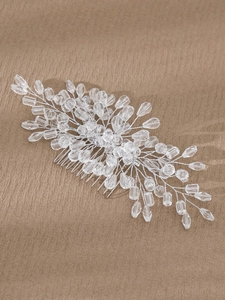 Detail view of handmade bridal hair comb with crystal beads and silver wire on brown fabric