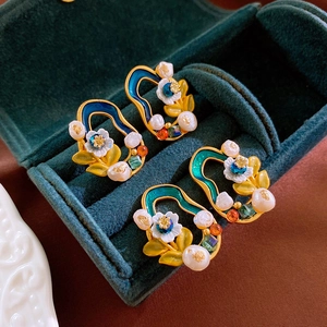 Detail view of retro floral earrings with pearls and crystals in a velvet jewelry box