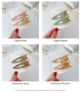 Detailed view of cat-shaped acetate hair clips in pink, green, gray, and purple colors
