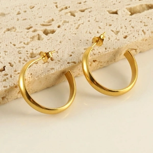 Minimalist matte 18k gold plated C-shaped hoop earrings on elegant stone display