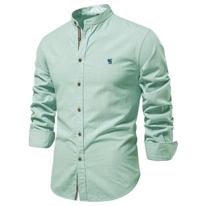 Détail de la texture d'une chemise en lin vert menthe avec broderie sur la poitrine