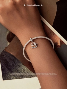 Detail of s925 silver coffee cup charm with crystal inlay on braided mesh bracelet