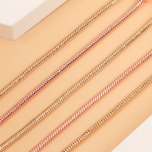 Close-up of rose gold snake bone chain bracelets with polished metallic texture