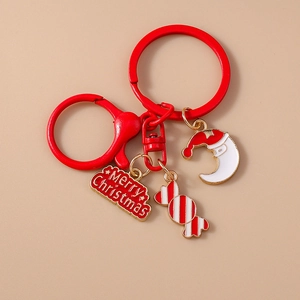 Detailed close-up of Christmas moon and candy cane enamel charms on a red keychain ring