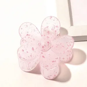 Detail view of a pink translucent flower claw clip with elegant ink droplet pattern
