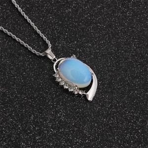 Elegante Silberhalskette mit ovalem Opal-Anhänger und Kristallakzenten auf schwarzem Grund