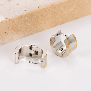 Minimalist two-tone stainless steel hoop earrings in silver and gold on a stone base