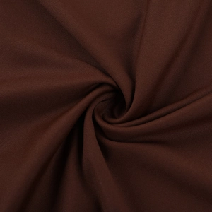 Makroaufnahme von dunkelbraunem Strickstoff mit eleganten spiralförmigen Falten