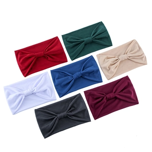 Detailed overhead view of multiple solid color knotted yoga headbands in various shades