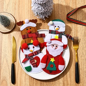 Christmas silverware holder set with Santa and snowman designs on a festive table