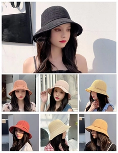 Detail view of woven straw sun hats in six vibrant colors with stylish side ribbons