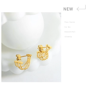 Close-up of golden multi-layer beaded tassel earrings with half-moon curved chain detail