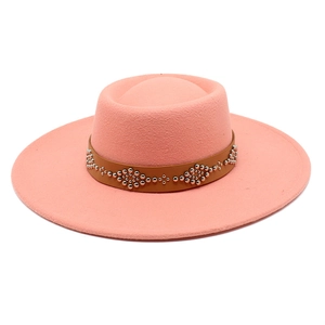 Detail of coral pink wool felt fedora with a studded brown leather hatband and flat brim