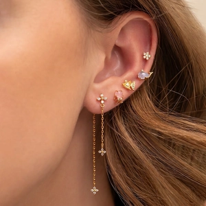 Marine animal earring set with gold octopus, whale and cross charms on a model