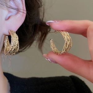 Detail of twisted gold wire texture on vintage style C-shaped hoop earrings