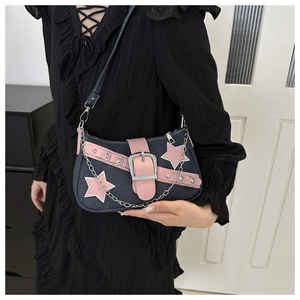 Detail of Y2K denim baguette bag with pink star patches and silver metal chain strap