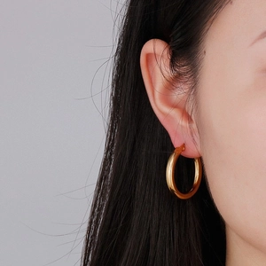 Classic 18K gold plated titanium steel hoop earrings shown on model's ear