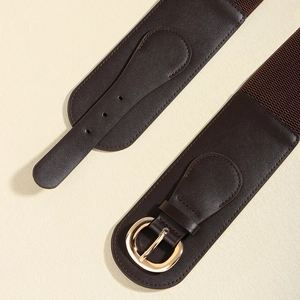 Detail of a wide dark brown PU leather belt featuring a classic golden metal ring buckle