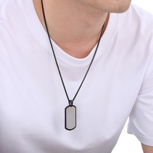 Detail of a men's silver dog tag pendant with black border on a black chain necklace