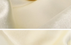 Gros plan sur un tissu satiné champagne clair montrant un éclat et une texture soyeuse