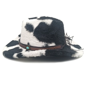 Detail of cow print cowboy hat showing plush texture, turquoise gemstone and brown leather band