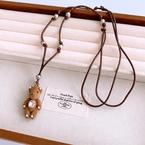 Brown flocking bear pendant necklace with white pearls and sparkling rhinestone detail