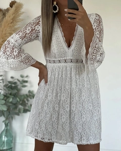 Detailed view of white lace mini dress with V-neck and hollow-out bell sleeve design