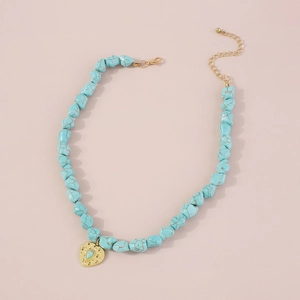 Detail of bohemian turquoise beaded necklace with gold heart pendant and evil eye charm