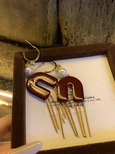 Detail of French style earrings with pearls and wine red resin U-shape tassels