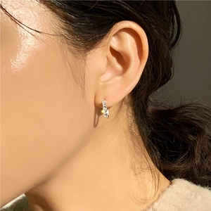 Side view of model wearing a delicate 925 sterling silver huggie hoop with cubic zirconia