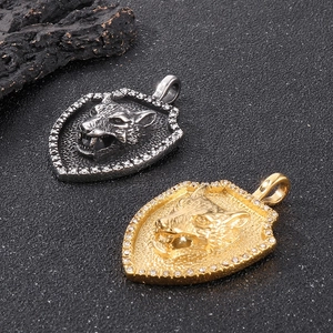 Detail of vintage wolf head shield pendant with crystals in gold and silver finish