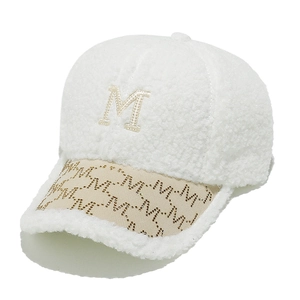 Detailed macro view of white plush baseball cap with M letter embroidery and rhinestones
