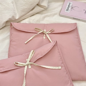 Dettaglio delle borse trapuntate rosa in due misure con fiocchi di nastro bianco