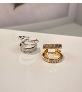 Detail of gold and silver multi-layer ear cuffs with pearls and baguette zircons