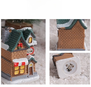 Detail view of glowing resin Christmas house showing textures and the battery compartment