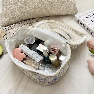 Top view of blue floral cosmetic bag interior with mesh pockets and makeup storage