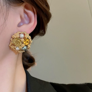 Close-up of vintage gold flower earrings with white pearls and yellow crystal