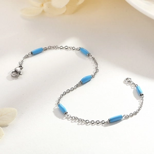 Détail du bracelet chaîne argenté avec perles tubes bleu clair et fermoir mousqueton