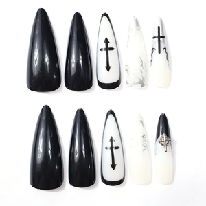 Detail of gothic stiletto press-on nails with 3D silver cross and marble patterns