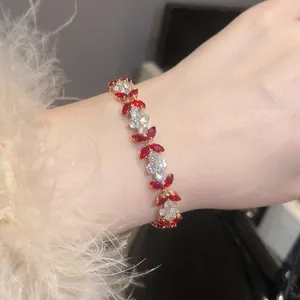 Exquisite gold flower bracelet with red marquise gemstones and zircon petals on wrist