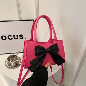 Pink bow handbag with black ribbon and crossbody strap for a sweet elegant summer style