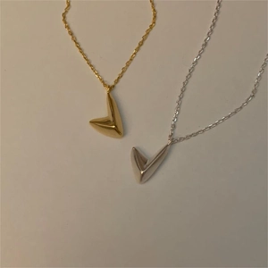 Detailed view of silver and gold irregular V-shaped necklaces in minimalist design